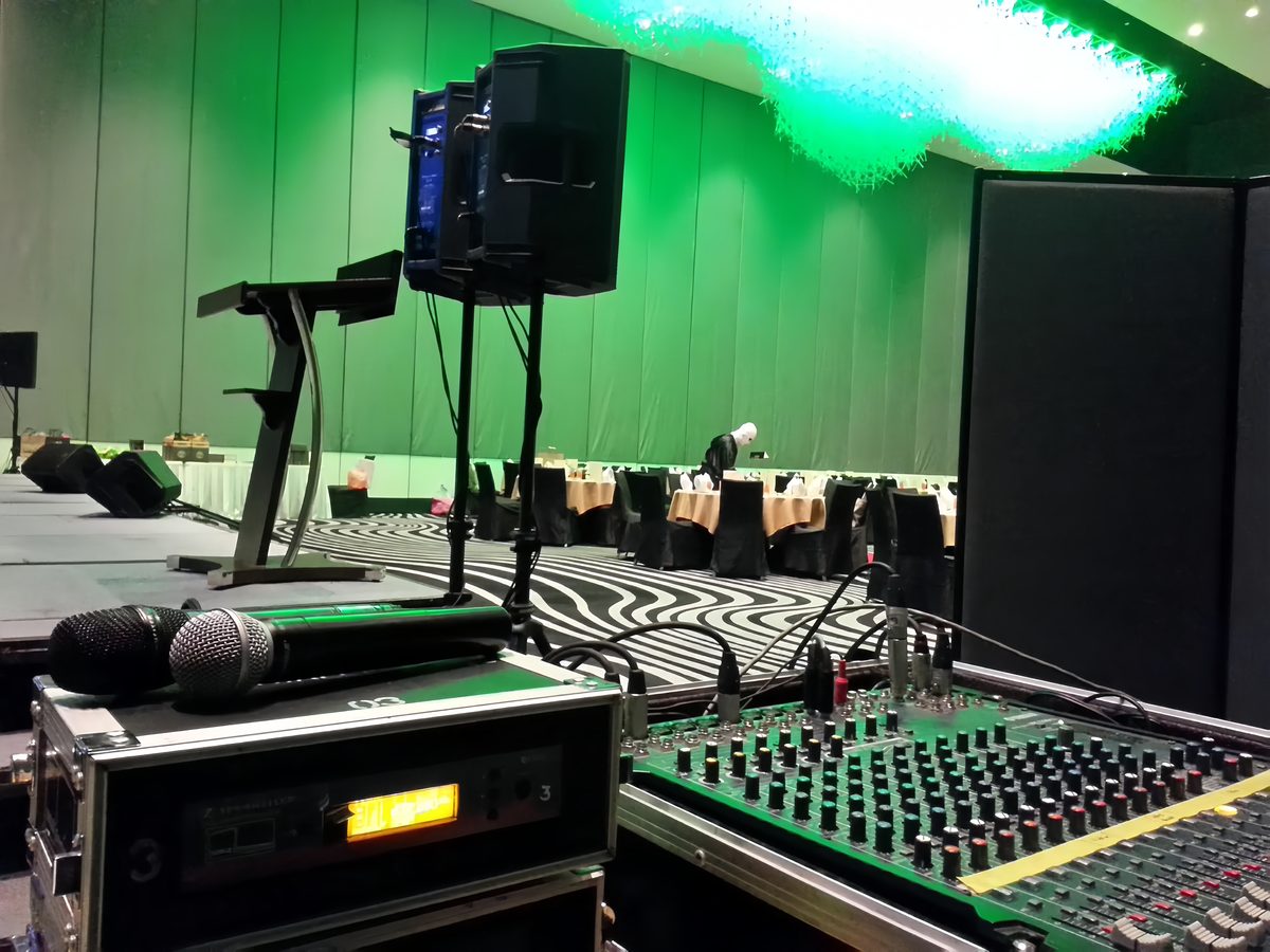 Wireless microphones and mixing console set up front-of-house in a ballroom