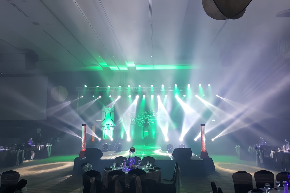 Green and white beam lighting over a ballroom stage