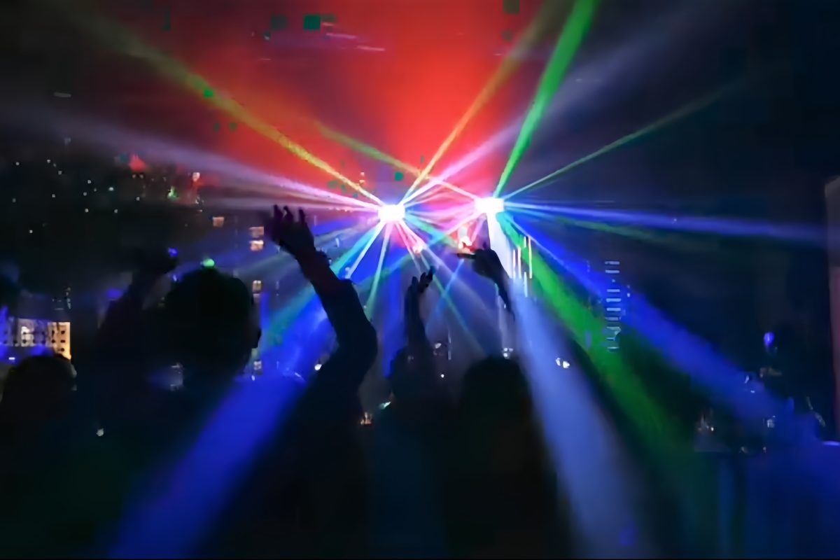 Laser fans over a packed dance floor