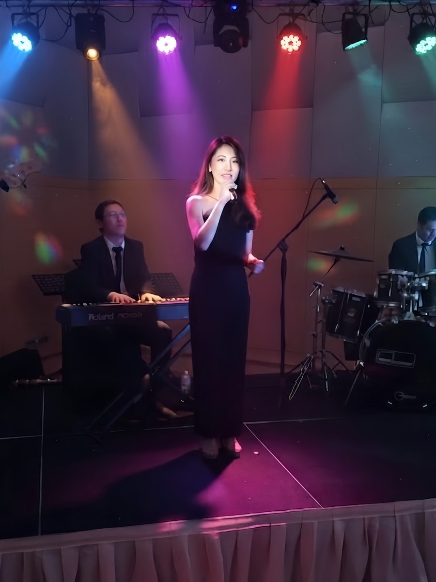 Vocalist fronting the band on stage under coloured lighting