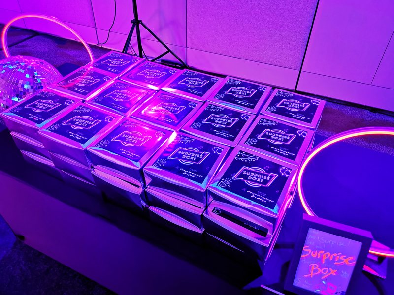 Stacked surprise boxes lit by neon tubes