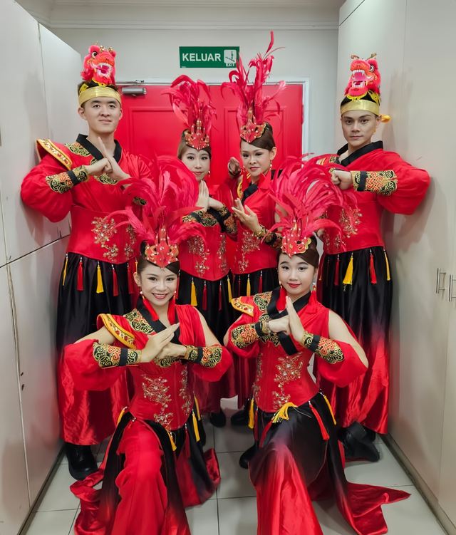 Festival troupe in red with phoenix headdresses