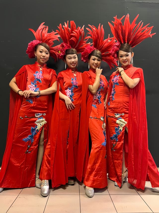 Dancers in red capes and embroidered gowns
