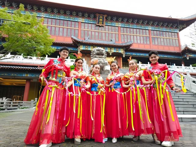 Troupe in red outside a Chinese temple