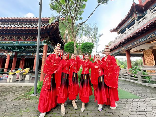 Red-gowned dancers at a temple courtyard