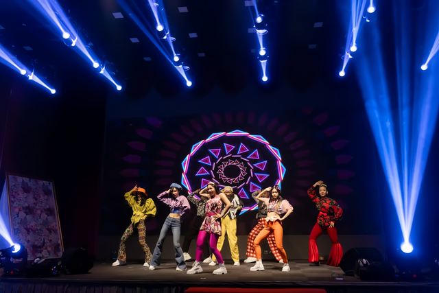Dance company on a mandala-lit stage