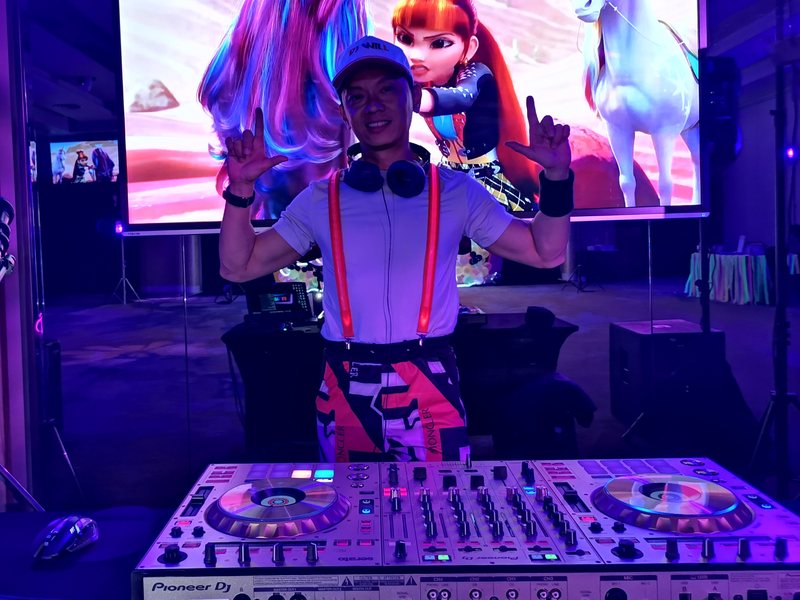 DJ Will behind a Pioneer console at a family party
