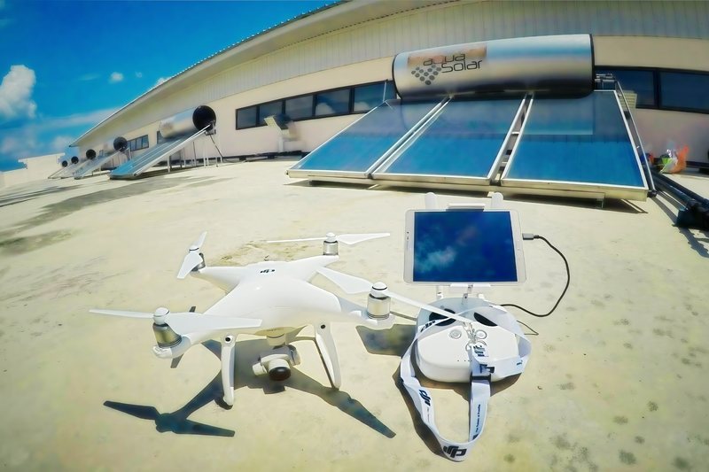 Drone on a rooftop beside a solar-panel array