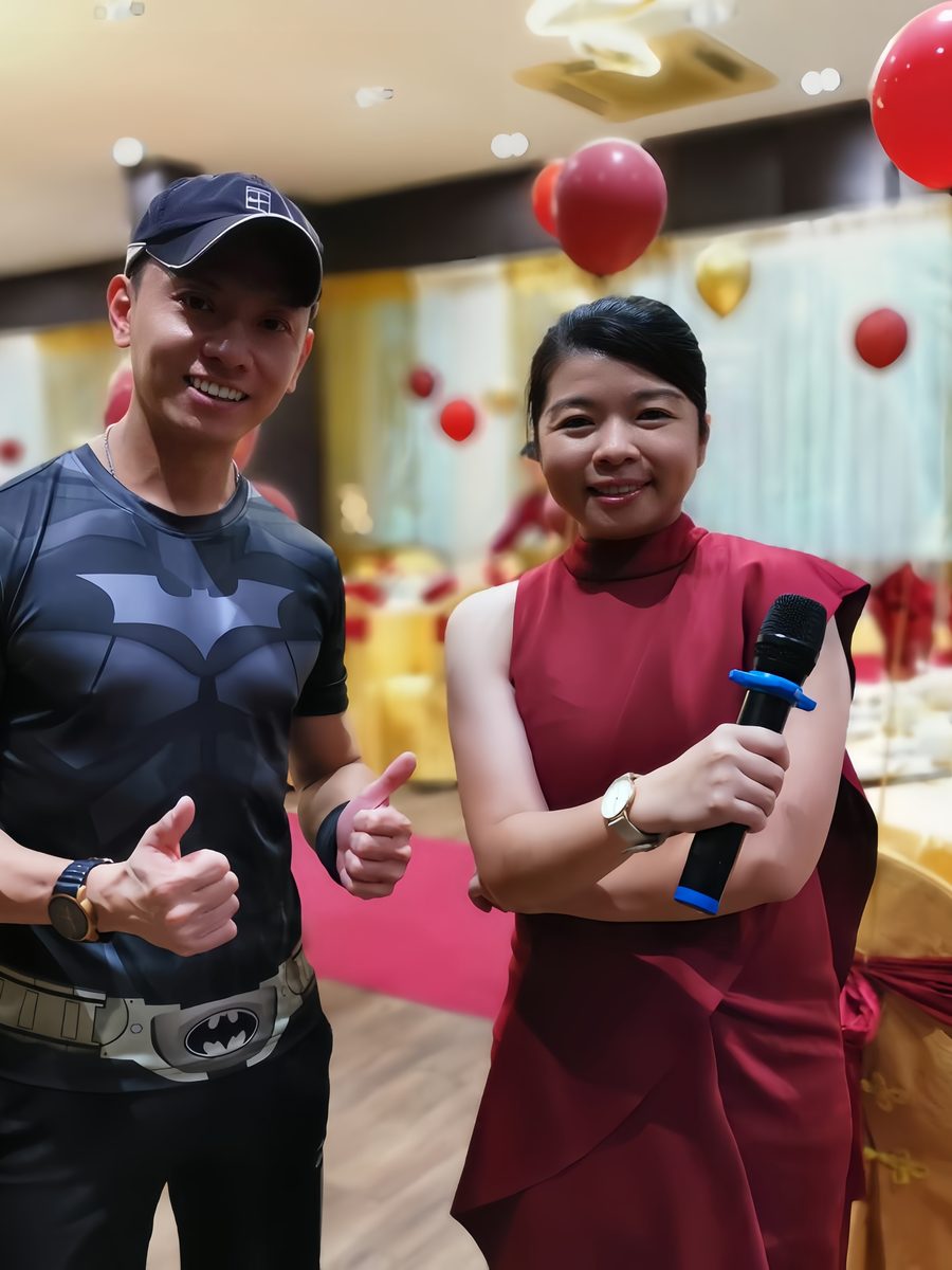 Emcee on the microphone beside the mixing desk in a ballroom