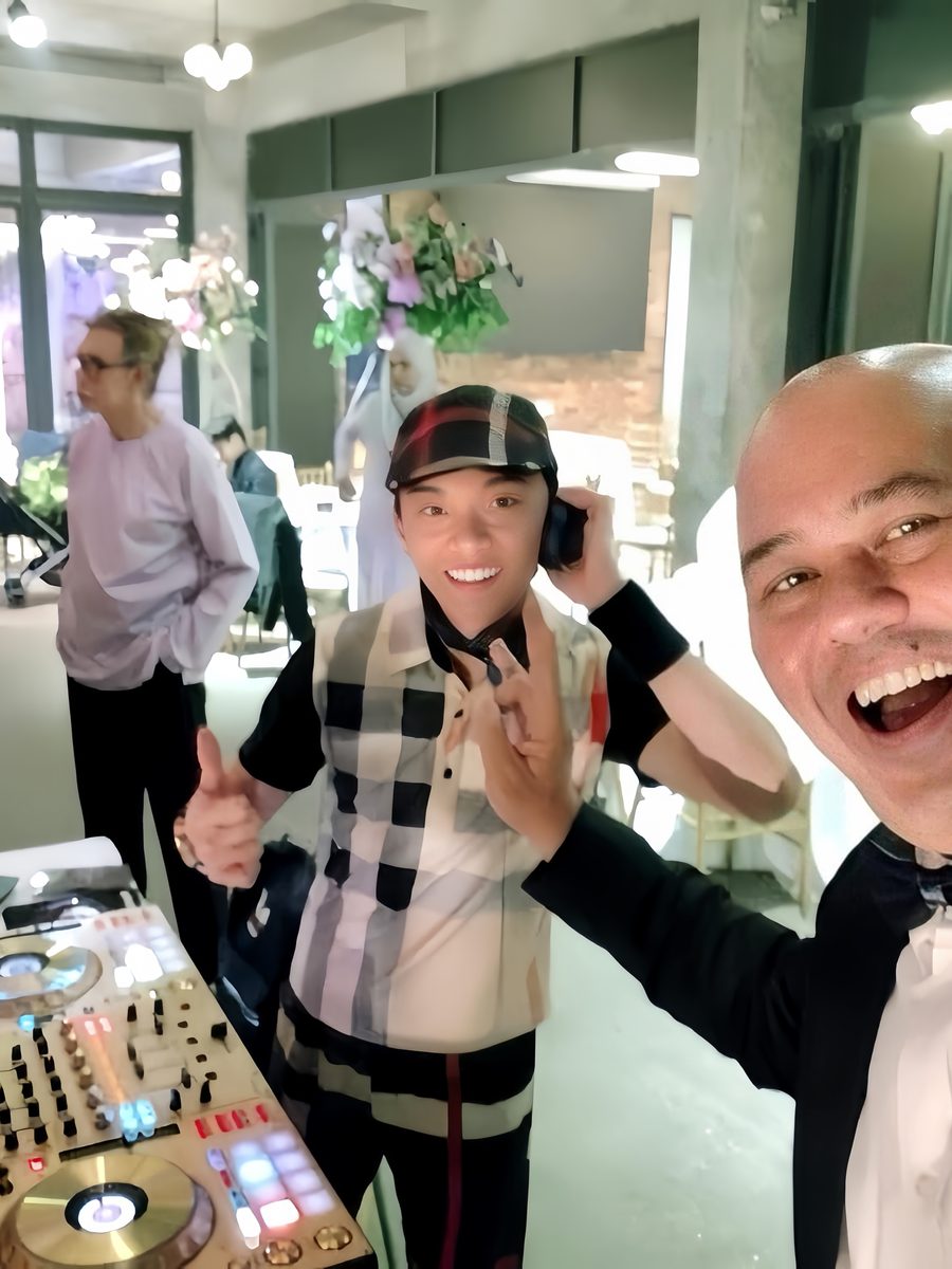 Emcee in black tie working alongside the DJ booth at a wedding