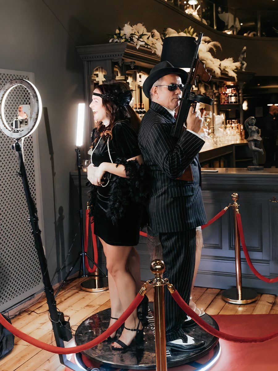 Guests posing on a 360 video booth in Gatsby costume