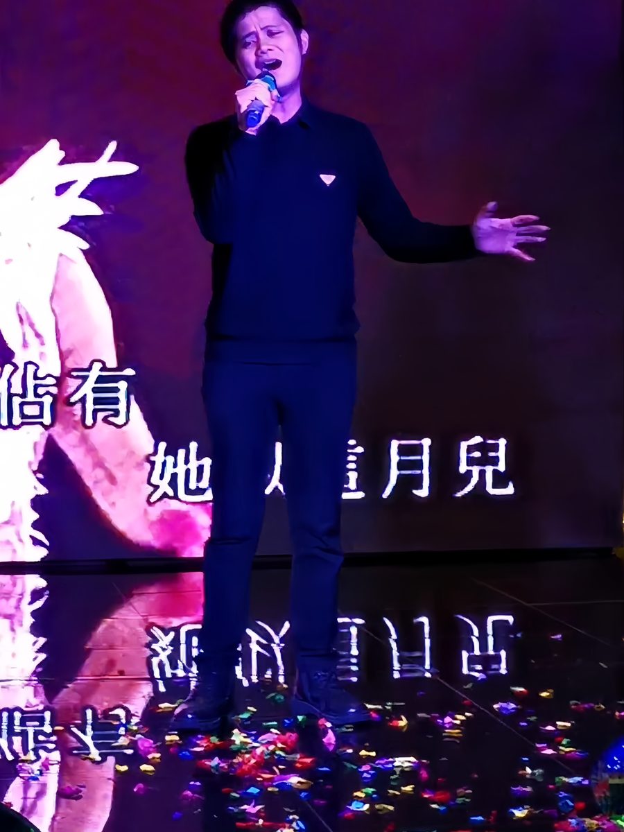 Vocalist performing with a live band against an LED wall