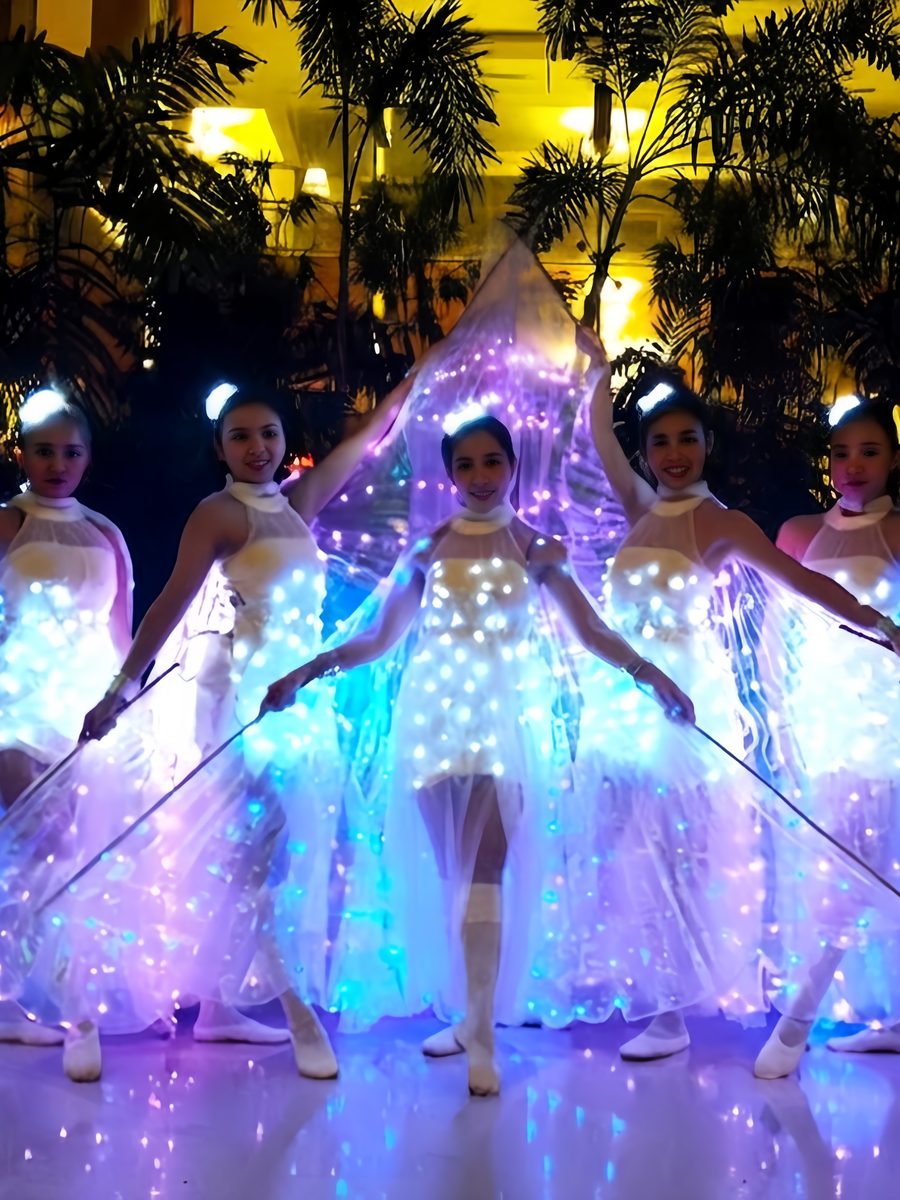 Dancers in illuminated LED butterfly-wing costumes