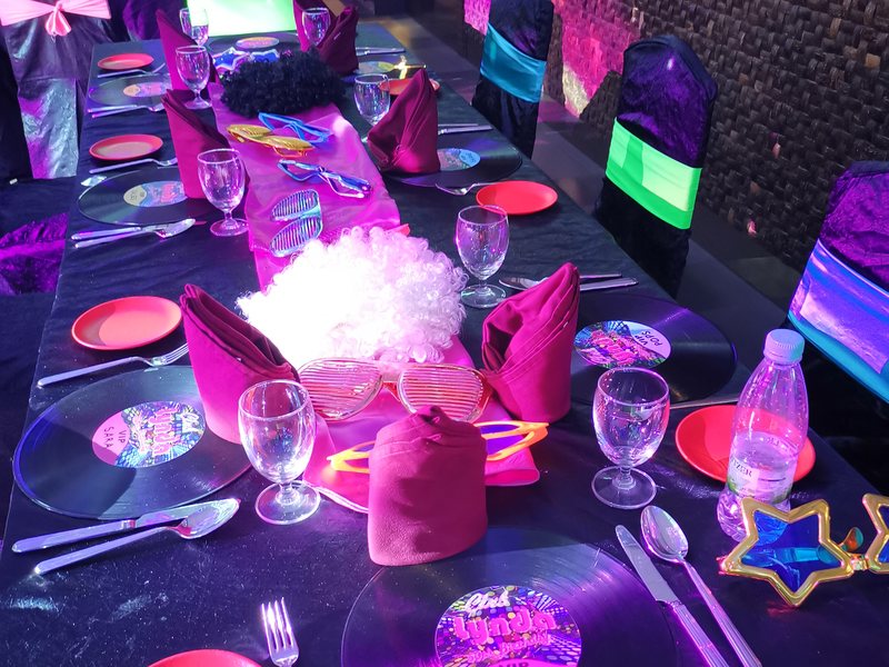 Vinyl-record table settings laid for a themed private party