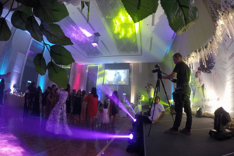 Videographer covering a wedding reception under coloured lighting