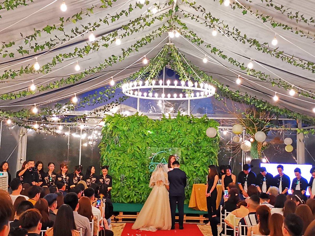 Ceremony under a garden marquee, the couple at the altar