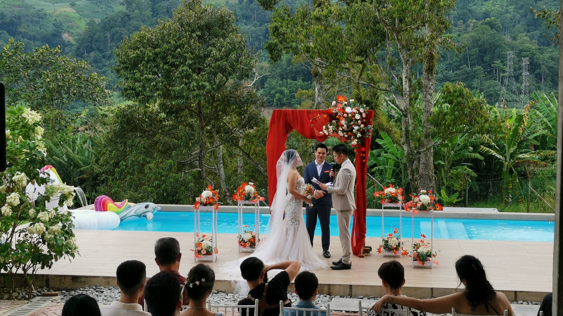 Poolside wedding ceremony, the couple at the altar with guests seated